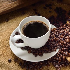 a cup of coffee surrounded by coffee beans