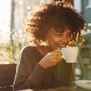 woman laughing with a coffee cup
